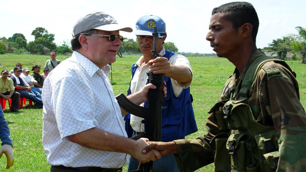 El entonces Alto Comisionado para la Paz, Luis Carlos Restrepo, recibe el arma de un miembro del Bloque Vencedores de Arauca durante el acto de desmovilización. Diciembre de 23 de 2005, Tame, Arauca. Foto: Oficina del Alto Comisionado para la Paz.